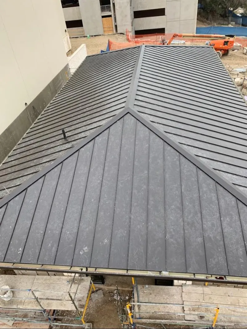 Commercial metal roof construction with crane equipment in Donna