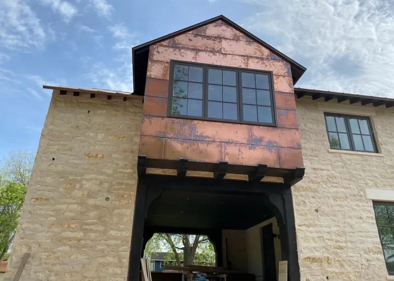 Copper metal panel facade on a stone building for Skylight Installation in Donna